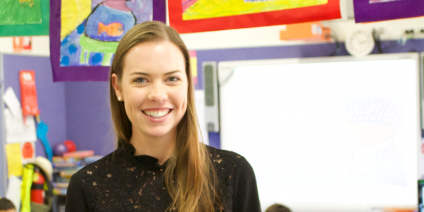 Lauren standing in a classroom in front of artwork