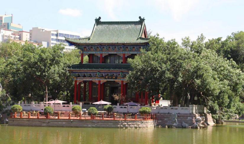 A traditional Chinese tea house next to a lake