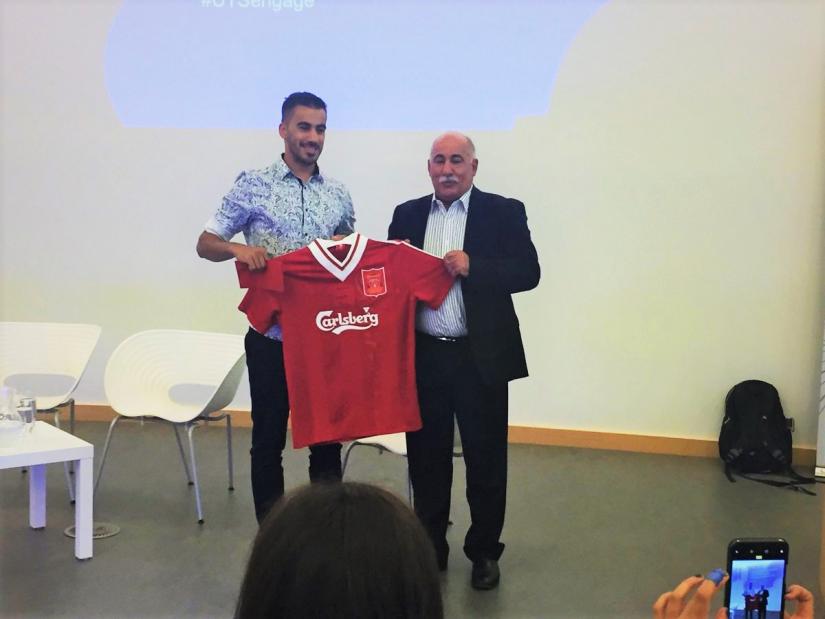 Hakeem Al-Araibi is presented with a shirt signed by Liverpool legend Robbie Fowler