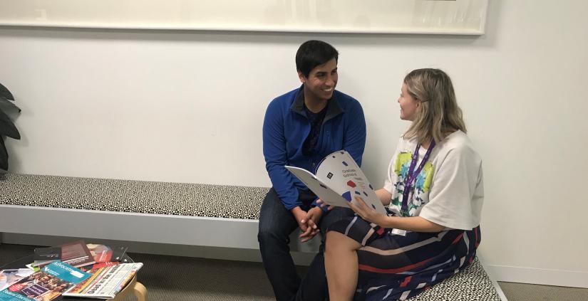 Male student speaking to female staff