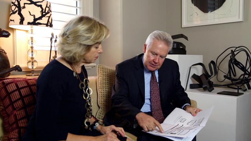 Woman, left and Jim Flook, right, consult floorplan documents.