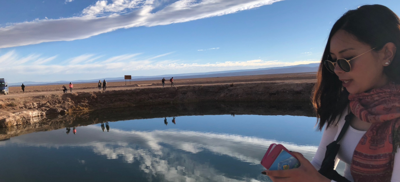 Rochelle walking next to a lake in the Chilean desert