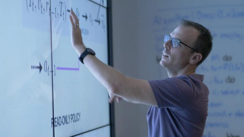 QSI Dr Christopher Ferrie presenting in front of a large monitor