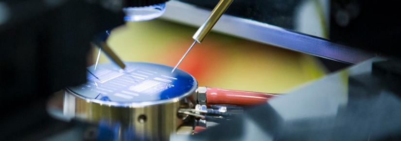 Two needles soldering onto a microchip under microscope