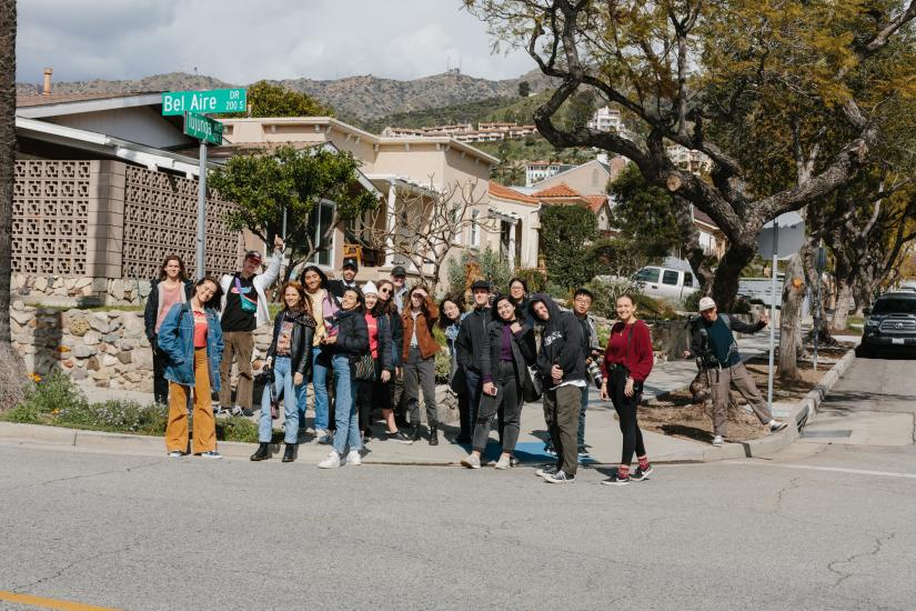 A group of photography students stand on the corner of a Californian street