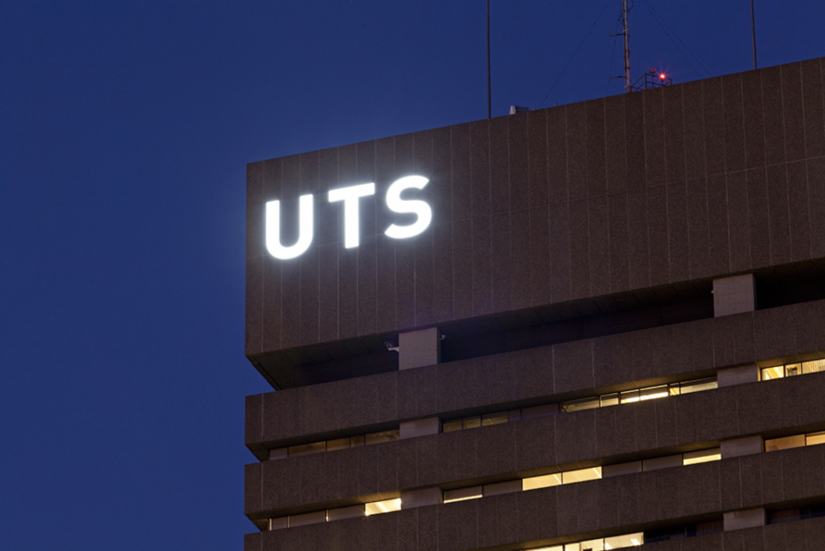 Top corner of UTS tower with illuminated letters by night