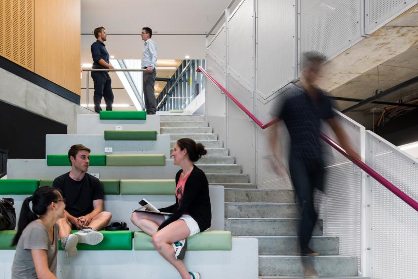 3 people sit on seats along a stairway