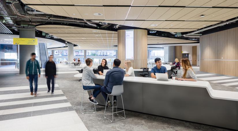 Students sit at long desks in conversation