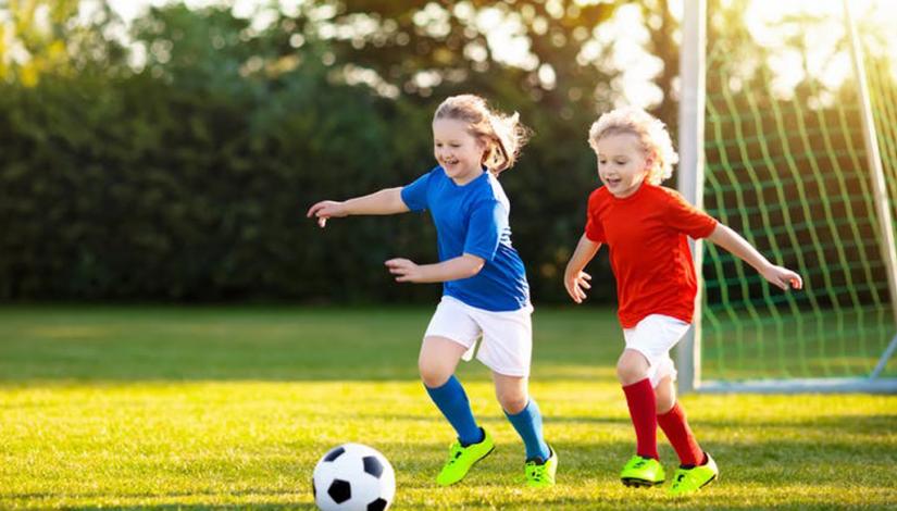 Two young girls playing football at a local park, provided by shutter-stock via The conversation