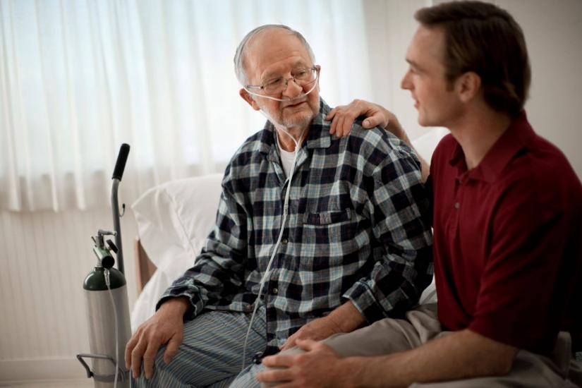 Man receiving oxygen therapy and carer