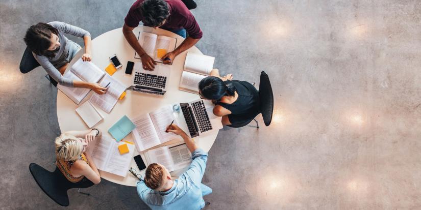 Aerial view of five students working at a round table