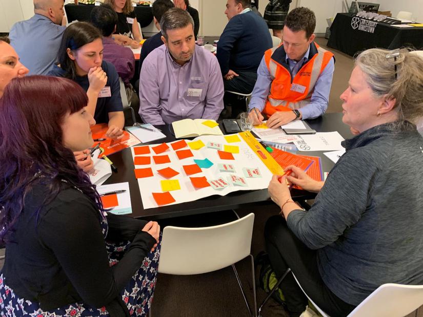 A group sit around a table with post-it notes