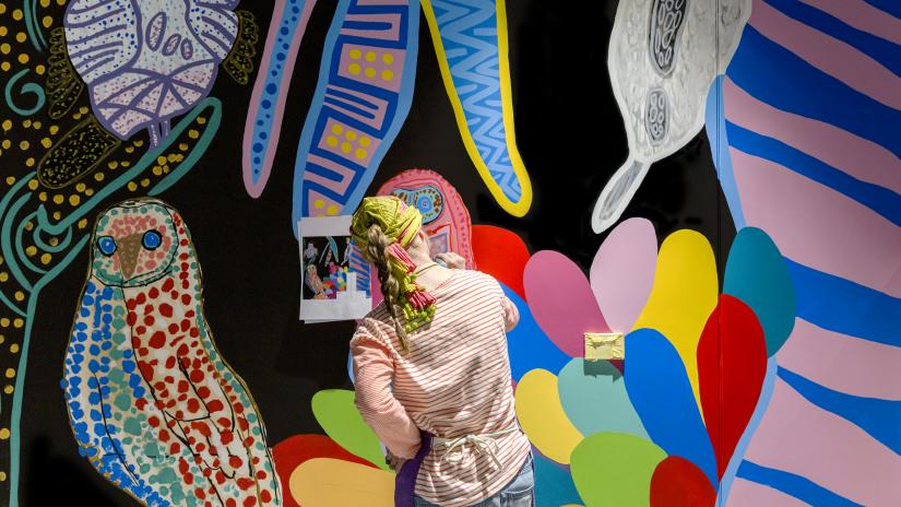 Artist Meagan Pelham painting the Bird Life Jungle Disco mural