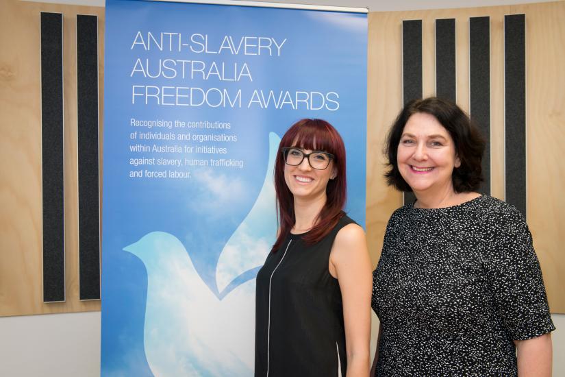 The Anti-Slavery team standing in front of the Freedom Awards pull up banner