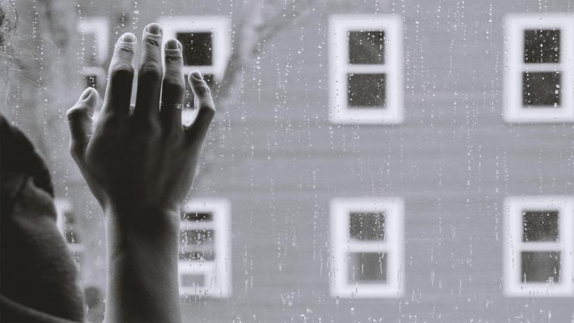 A woman's hand pressed against a window