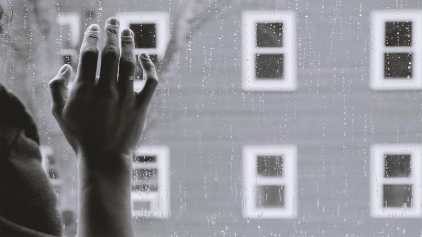 A woman's hand pressed against a window 