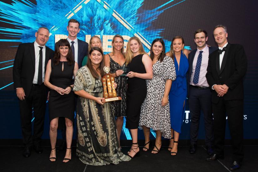 11 people from the UTS Club of the Year in formal wear, smiling and holding a trophy