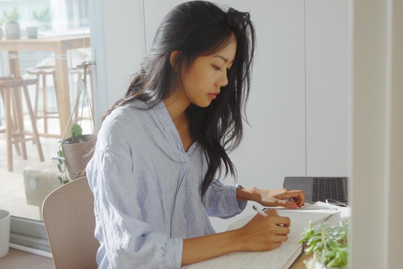 Rachel Tse working at a desk in a light cafe setting