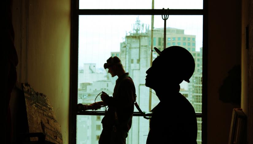 Silhouette of two construction workers inside a building