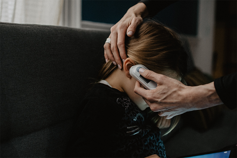 A mother checks a child's fever