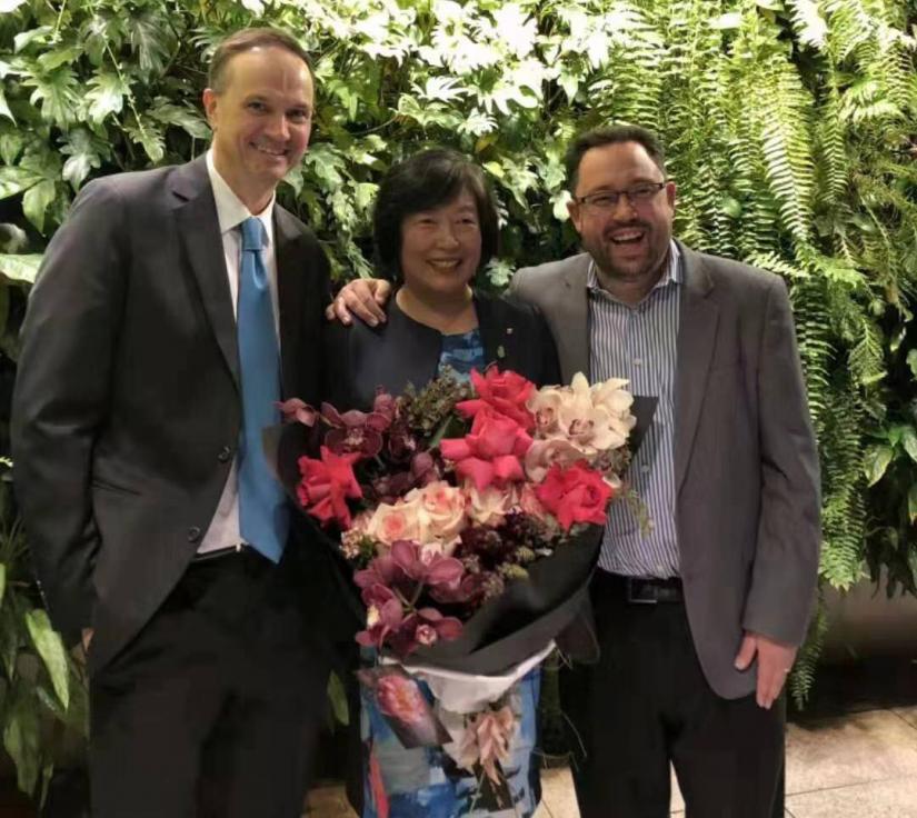 Professor Ian Burnett (left) and Professor Michael Blumenstein congratulate Distinguished Professor Jie Lu (who is holding a huge bunch of flowers) on her achievement as the first UTS academic to be awarded an Australian Laureate Fellowship
