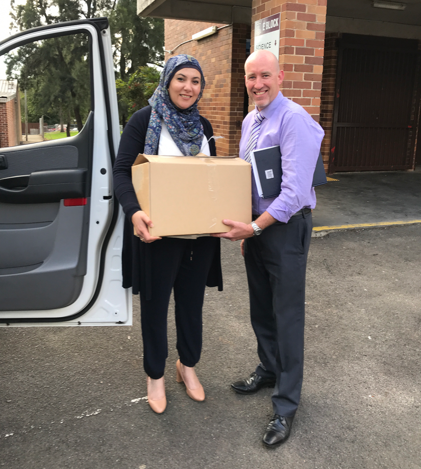 Handing over a box of 40 laptops to teaching staff at Sir Joseph Banks High School.