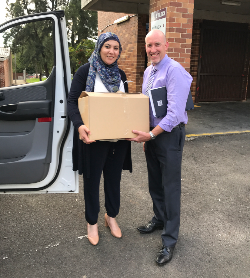 Handing over a box of 40 laptops to teaching staff at Sir Joseph Banks High School.