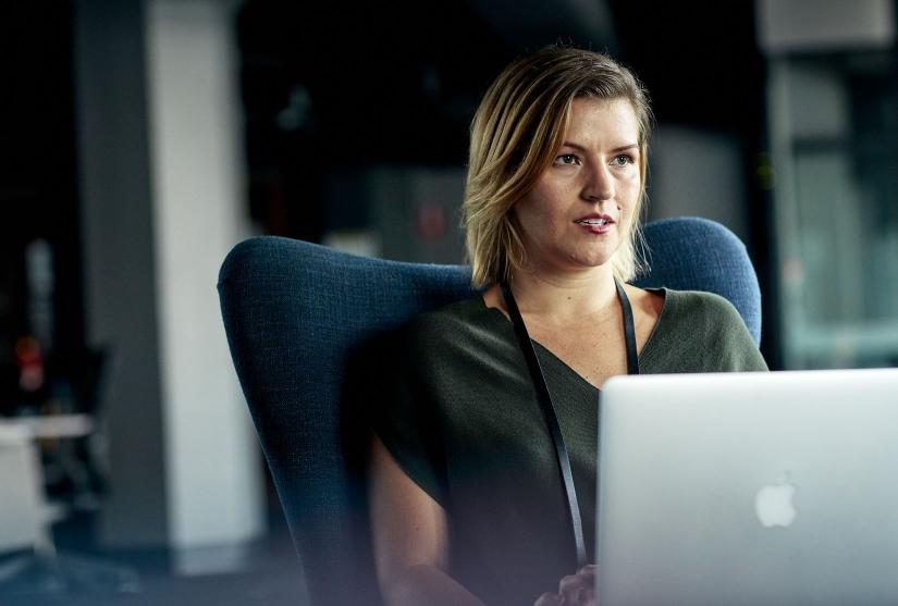 Woman in green blouse on apple laptop