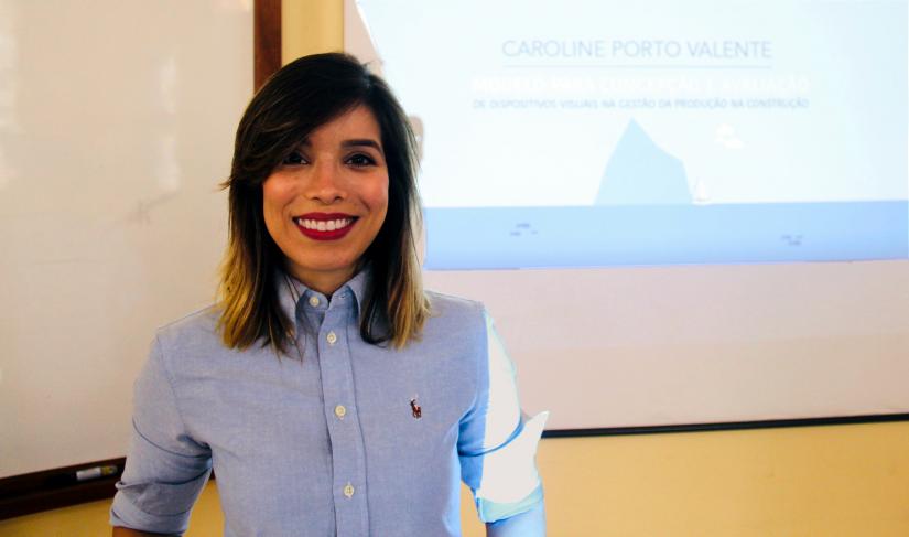 a woman stands in front of a presentation projection