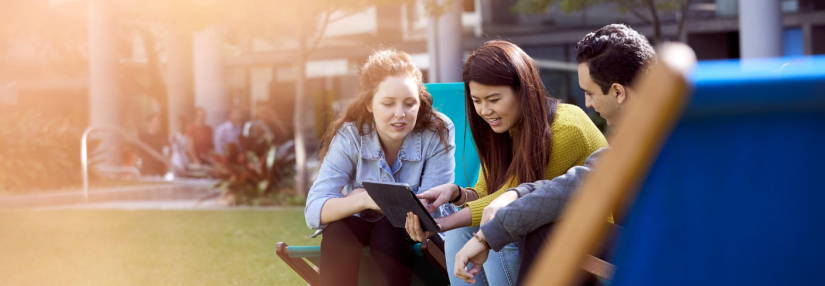 UTS students on the Alumni Green looking at iPad