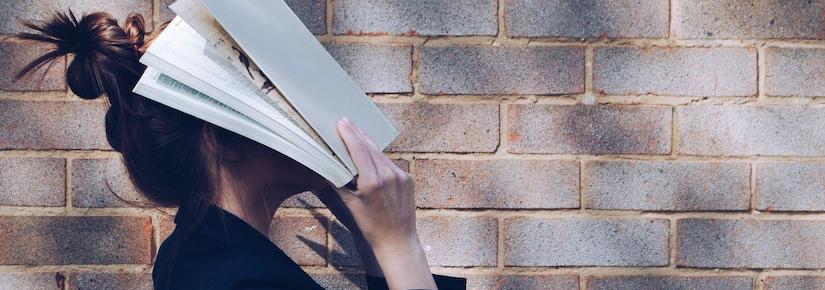 Girl holding book on her face