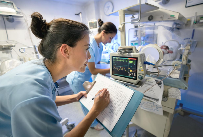 Nurse recording patient information on chart