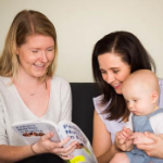 Child and Family Health Nurse sits with mother and child reading