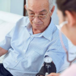 Male patient has vital signs checked by a nurse