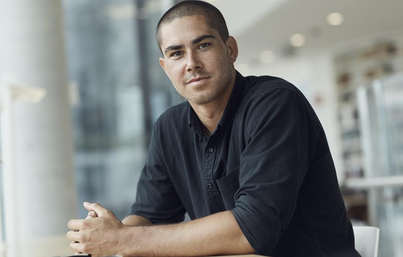 Young man sitting down looking at the camera