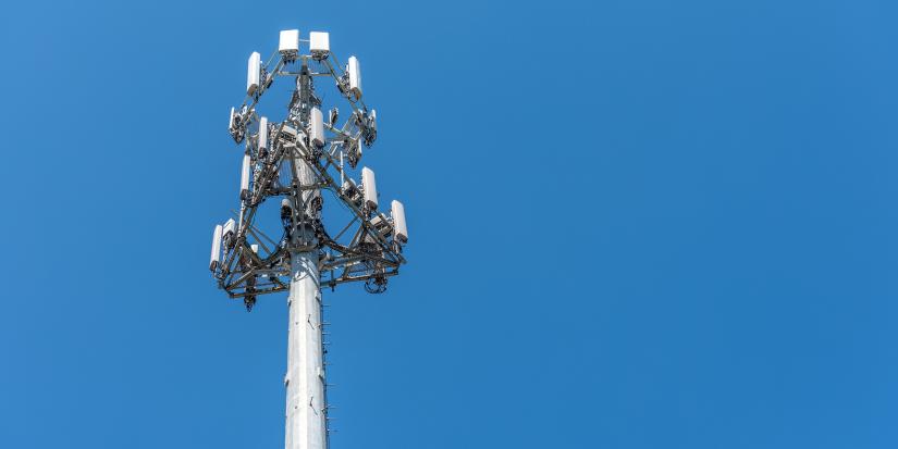 Base station antenna communication tower in front of blue sky on a sunny day