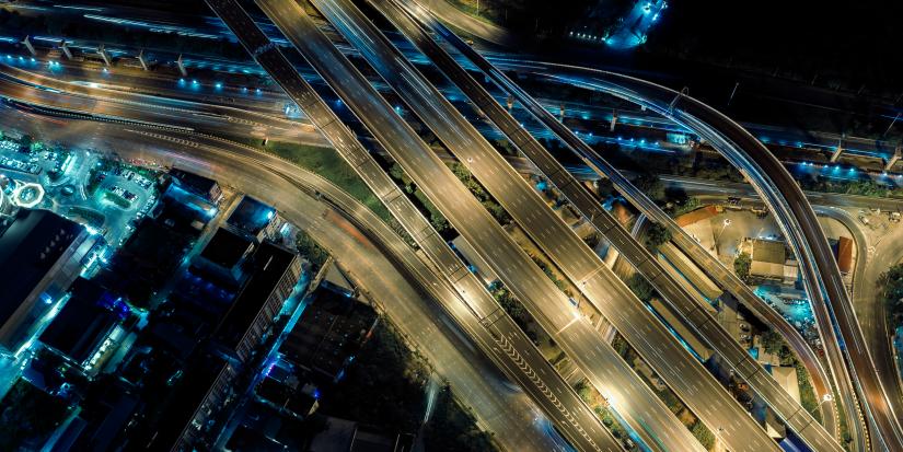 Aerial view of multi lane overhead freeway system with blue toned lights