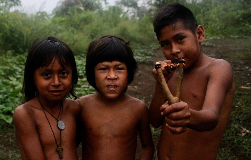 Three children, one holding slingshot