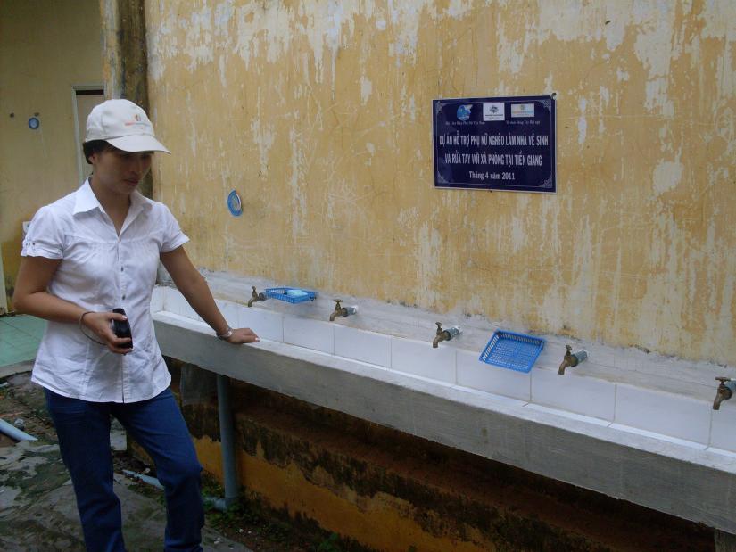 Woman standing beside a hand washing sink