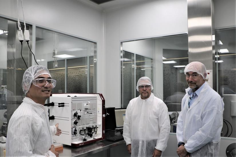 Three men in safety gear in lab