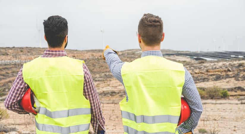 Two men pointing to land in the distance