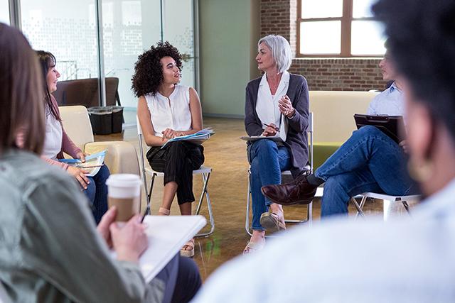 People sitting in a circle with pen and paper