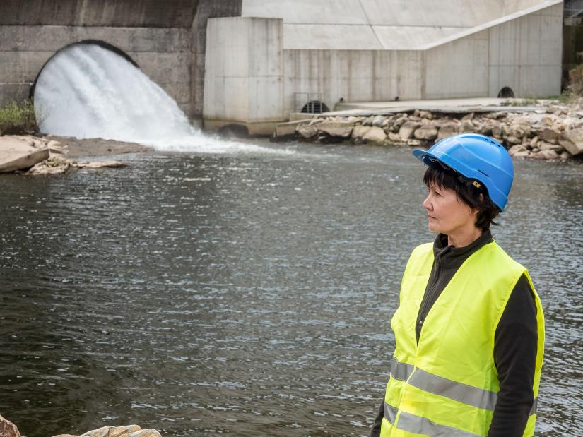 Woman in high vis vest standing in front of water