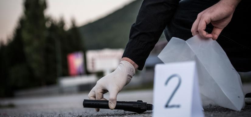 Gloved hand picking up gun