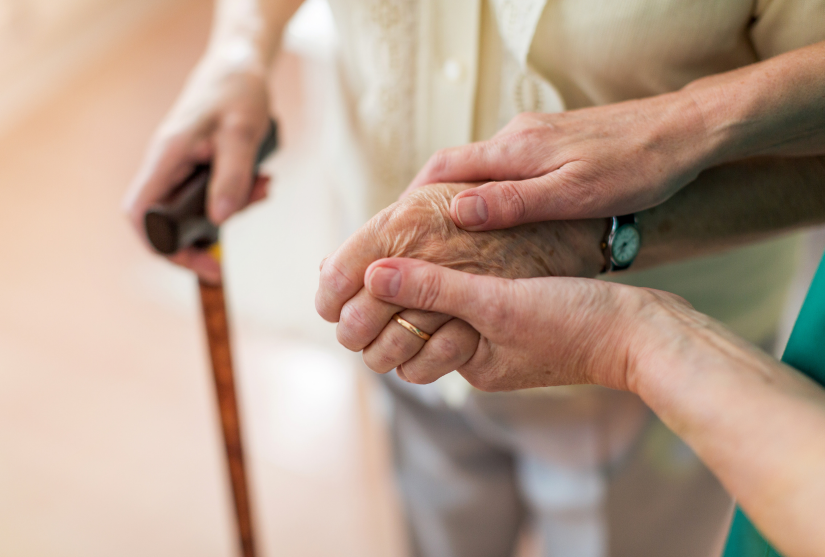 Nurse holds the hand of an elderly patient