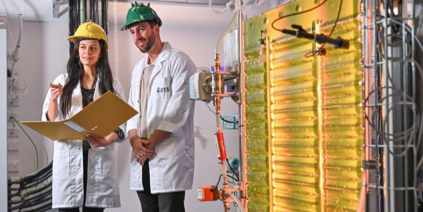 A woman and a man check the readings in a folder at the algae lab