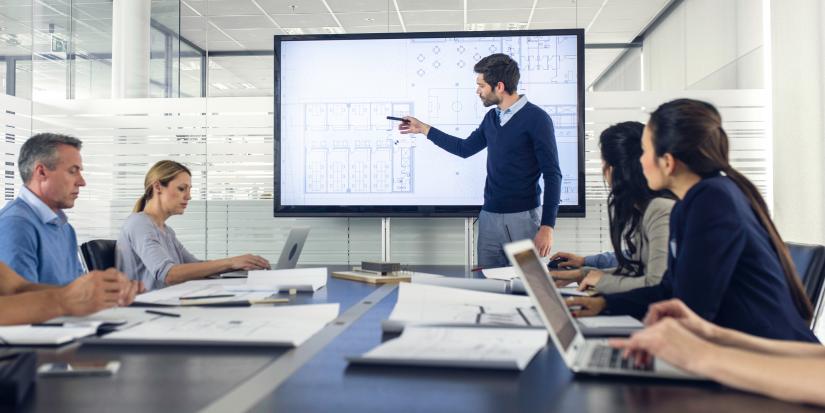 Professionals work on project using a large screen