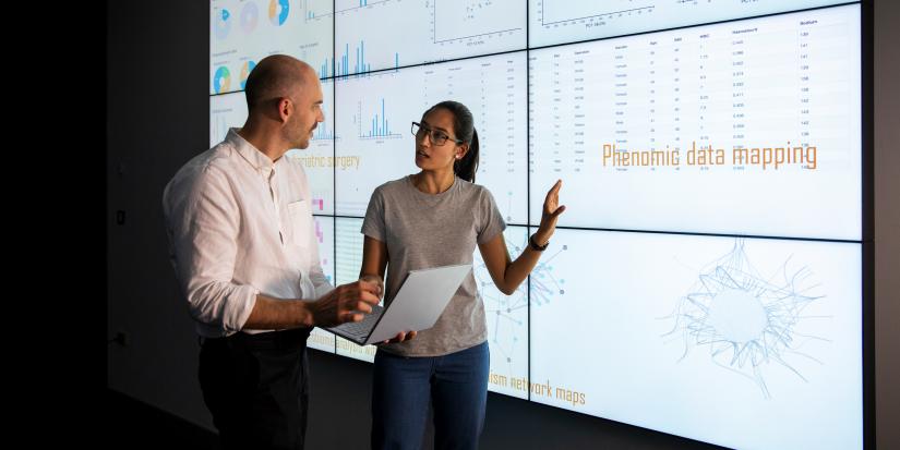 Discussion in front of a large information device about universal detection of genes in a specific biological sample.