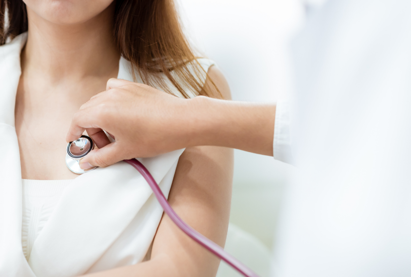 Doctor using stethoscope to examine patient's heart