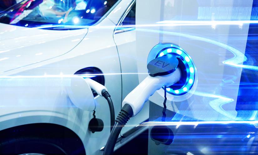 An electric car is plugged in to power source
